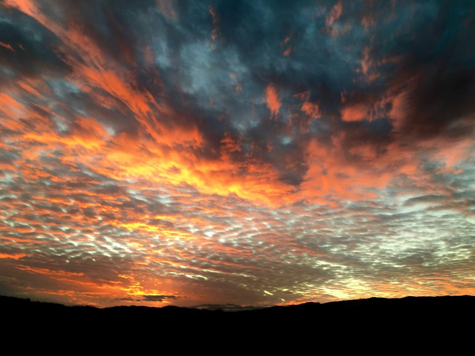 a colorful sky with a few clouds in the distance